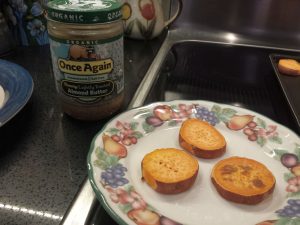 baked sweet potato slices, and a jar of almond butter, ready for spreading