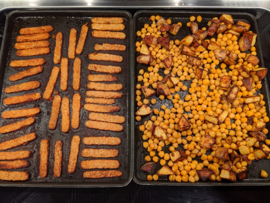 Finished tempeh on the left, looking golden. Finished potatoes and chickpeas on the right, with the potatoes also looking golden.